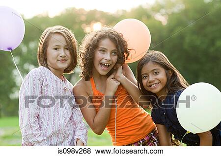 Stock Photo - Girls at birthday party holding balloons. Fotosearch