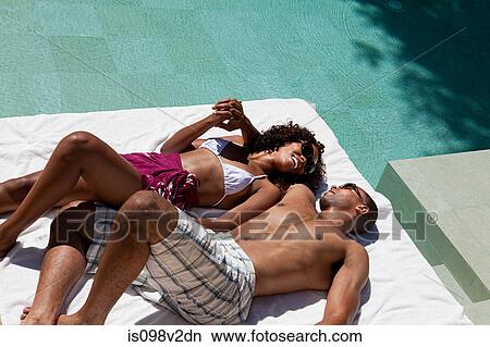 Couple lying by pool View Large Photo Image Picture - Couple lying by pool. Fotosearch