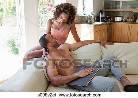 Couple relaxing on sofa View Large Photo Image Stock Photograph - Couple relaxing on sofa. Fotosearch