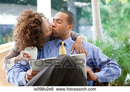 Stock Photograph - Kissing couple with laptop. Fotosearch