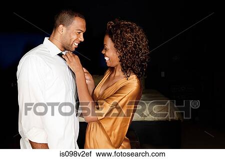 Stock Image - Woman tying boyfriend's tie. Fotosearch