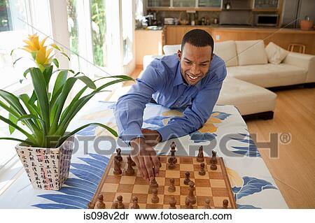 Stock Photography - Young man playing chess. Fotosearch
