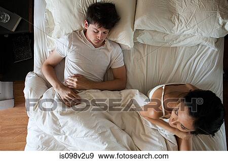 Man sleeping and woman restless in bed View Large Photo Image Stock Photo - Man sleeping and woman restless in bed. Fotosearch