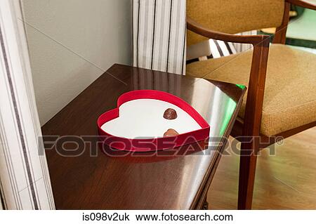 Stock Image - Two chocolates left in heart shaped box. Fotosearch