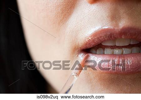 Stock Photography - Woman applying lipgloss. Fotosearch