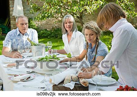 Stock Image - Family eating lunch outdoors. Fotosearch