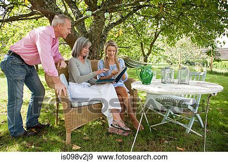 Family looking at book together View Large Photo Image Stock Photo - Family looking at book together. Fotosearch