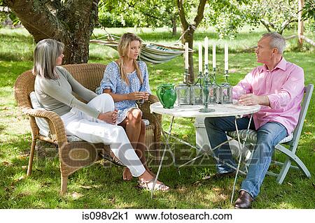 Stock Image - Family sitting at table. Fotosearch
