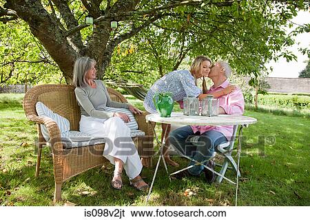 Stock Photograph - Family sitting at table. Fotosearch