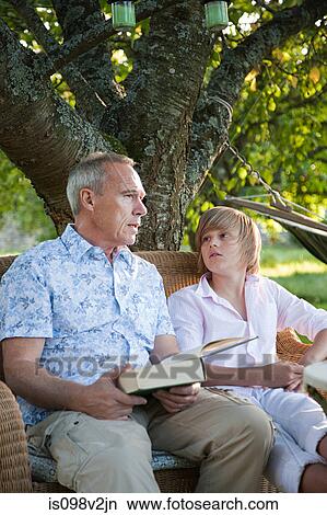 Father and son with book, in conversation View Large Photo Image Picture - Father and son with book, in conversation. Fotosearch