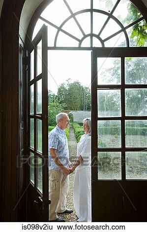 Stock Photograph - Mature couple by french doors. Fotosearch