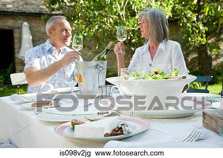 Stock Image - Mature couple having lunch outdoors. Fotosearch