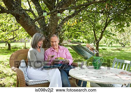 Mature couple sitting on chairs outdoors View Large Photo Image Stock Image - Mature couple sitting on chairs outdoors. Fotosearch