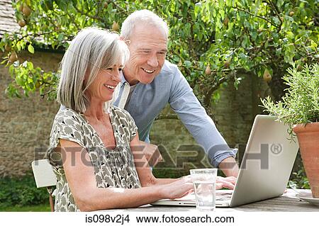 Mature couple using laptop View Large Photo Image Picture - Mature couple using laptop. Fotosearch