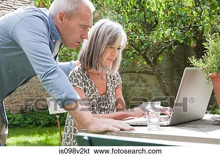 Stock Photograph - Mature couple using laptop. Fotosearch