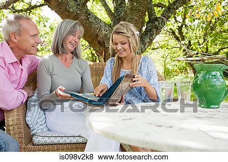 Stock Photo - Mature couple with their daughter in garden. Fotosearch