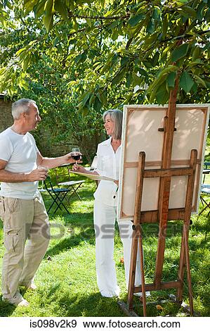 Mature couple, woman painting at easel View Large Photo Image Stock Photo - Mature couple, woman painting at easel. Fotosearch