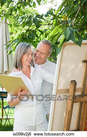 Mature couple, woman painting at easel View Large Photo Image Stock Photograph - Mature couple, woman painting at easel. Fotosearch