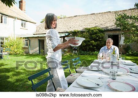 Stock Photography - Mature woman serving lunch. Fotosearch