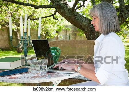 Picture - Mature woman using laptop. Fotosearch