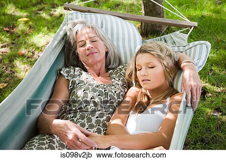 Stock Image - Mother and daughter relaxing in hammock. Fotosearch
