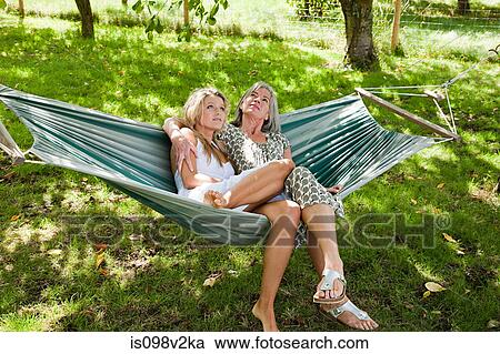 Stock Image - Mother and daughter relaxing in hammock. Fotosearch