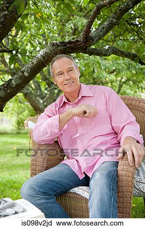 Stock Image - Senior man sitting on chair. Fotosearch