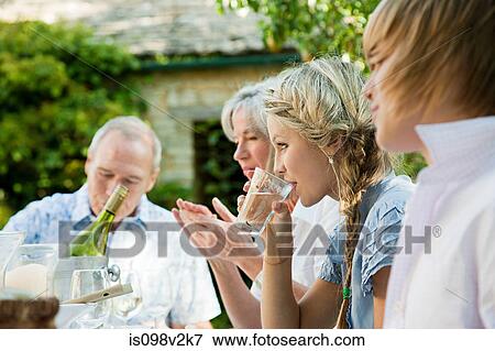 Stock Photo - Young woman drinking water with family. Fotosearch
