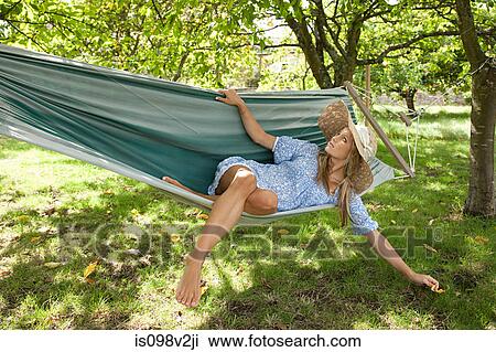 Stock Image - Young woman relaxing in hammock. Fotosearch