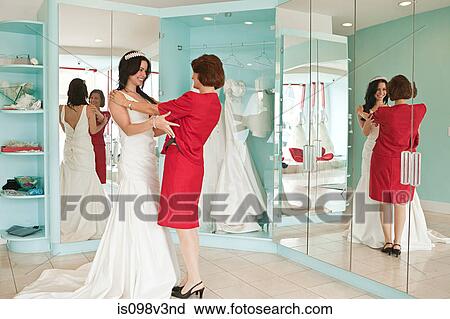 Daughter trying on wedding dress and tiara with mother View Large Photo Image Stock Image - Daughter trying on wedding dress and tiara with mother. Fotosearch