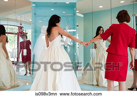 Daughter trying on wedding dress, holding hands View Large Photo Image Picture - Daughter trying on wedding dress, holding hands. Fotosearch