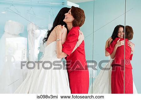 Daughter trying on wedding dress, embracing mother View Large Photo Image Stock Image - Daughter trying on wedding dress, embracing mother. Fotosearch