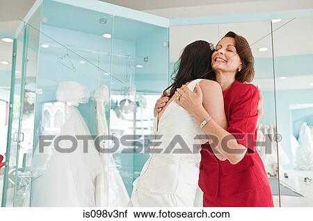Daughter trying on wedding dress, embracing mother View Large Photo Image Stock Image - Daughter trying on wedding dress, embracing mother. Fotosearch