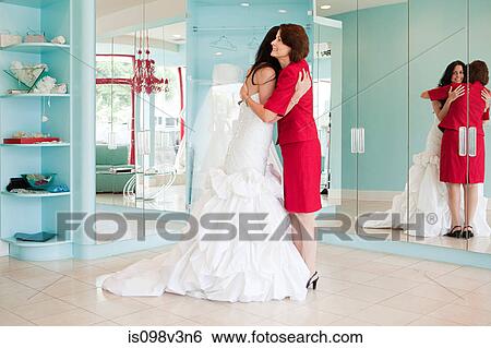 Daughter trying on wedding dress, embracing mother View Large Photo Image Stock Photograph - Daughter trying on wedding dress, embracing mother. Fotosearch