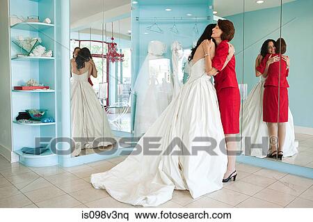 Daughter trying on wedding dress, embracing mother View Large Photo Image Stock Photography - Daughter trying on wedding dress, embracing mother. Fotosearch