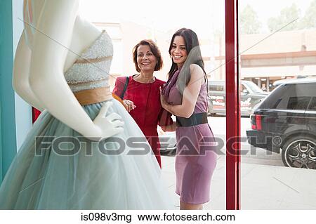 Mother and daughter looking at wedding dress in shop window View Large Photo Image Stock Image - Mother and daughter looking at wedding dress in shop window. Fotosearch