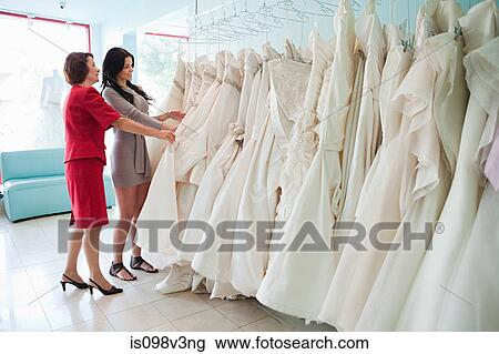 Mother and daughter looking at wedding dresses View Large Photo Image Stock Image - Mother and daughter looking at wedding dresses. Fotosearch