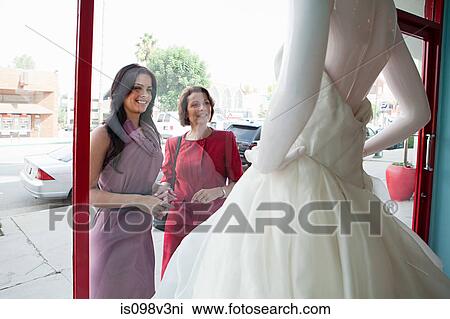 Mother and daughter looking at wedding dress in shop window View Large Photo Image Stock Image - Mother and daughter looking at wedding dress in shop window. Fotosearch