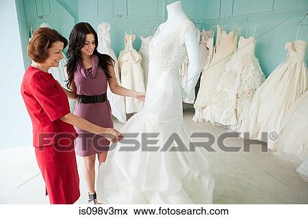 Mother and daughter looking at wedding dresses View Large Photo Image Stock Photo - Mother and daughter looking at wedding dresses. Fotosearch