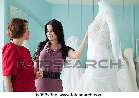 Stock Photo - Mother and daughter looking at wedding dresses. Fotosearch