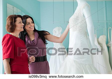 Stock Photography - Mother and daughter looking at wedding dresses. Fotosearch