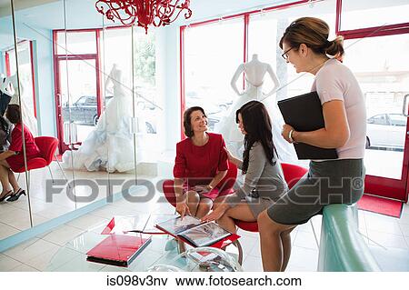 Mother and daughter talking to wedding dress designer View Large Photo Image Stock Photo - Mother and daughter talking to wedding dress designer. Fotosearch