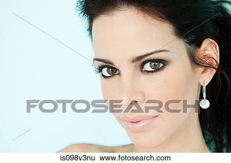 Young woman wearing earrings, studio shot View Large Photo Image Stock Photograph - Young woman wearing earrings, studio shot. Fotosearch