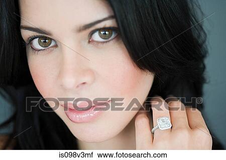 Stock Image - Young woman wearing engagement ring. Fotosearch