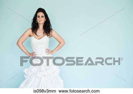 Picture - Young woman wearing white wedding dress, studio shot. Fotosearch