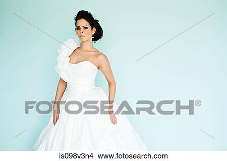 Young woman wearing white wedding dress, studio shot View Large Photo Image Picture - Young woman wearing white wedding dress, studio shot. Fotosearch