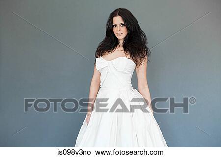 Young woman wearing white wedding dress, studio shot View Large Photo Image Picture - Young woman wearing white wedding dress, studio shot. Fotosearch