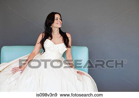 Young woman wearing white wedding dress, studio shot View Large Photo Image Stock Photo - Young woman wearing white wedding dress, studio shot. Fotosearch