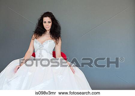 Stock Photography - Young woman wearing white wedding dress, studio shot. Fotosearch