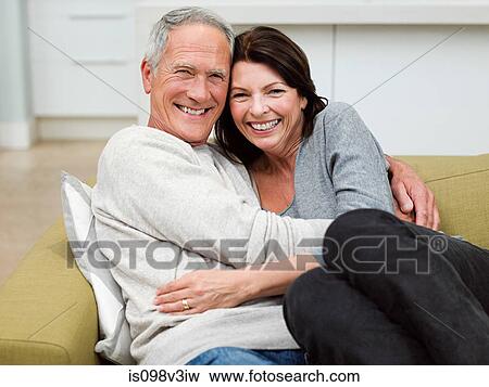 Mature couple embracing on sofa View Large Photo Image Stock Photo - Mature couple embracing on sofa. Fotosearch